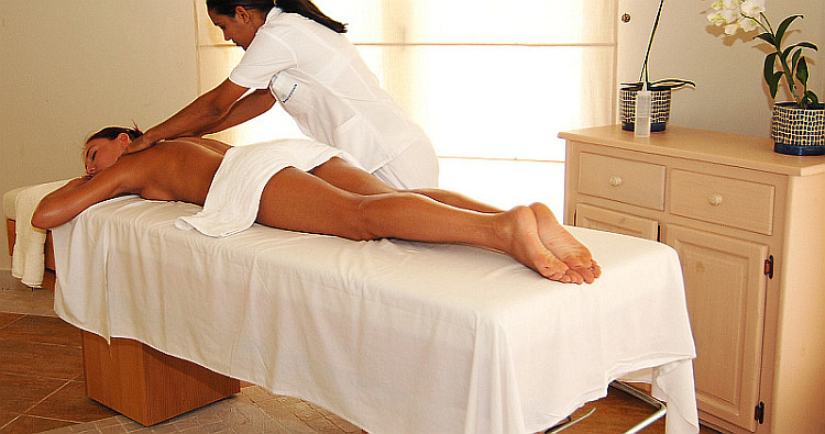 massage therapist working client in spa